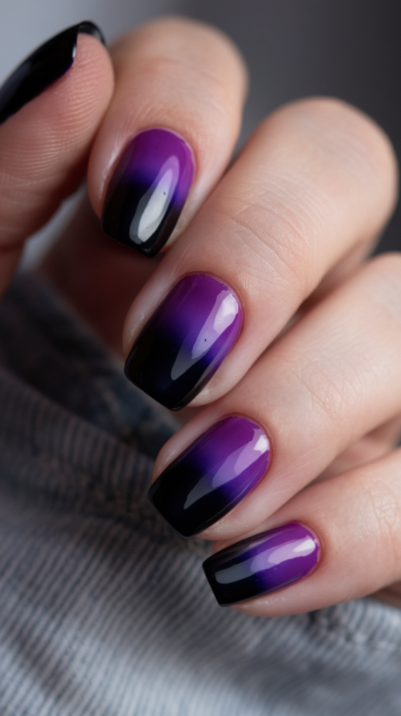 A bold gradient transitioning from black at the cuticle to dark violet at the tips, creating a dramatic ombre effect.