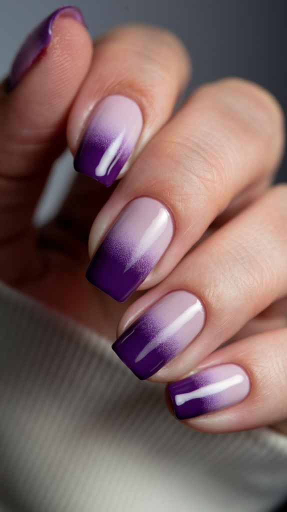 A smooth gradient transitioning from light lavender at the cuticle to deep violet at the tips, creating an elegant ombre effect with a glossy finish.