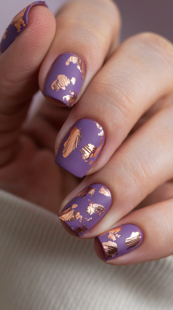 Matte violet nails decorated with delicate rose gold foil accents for a luxurious finish.

