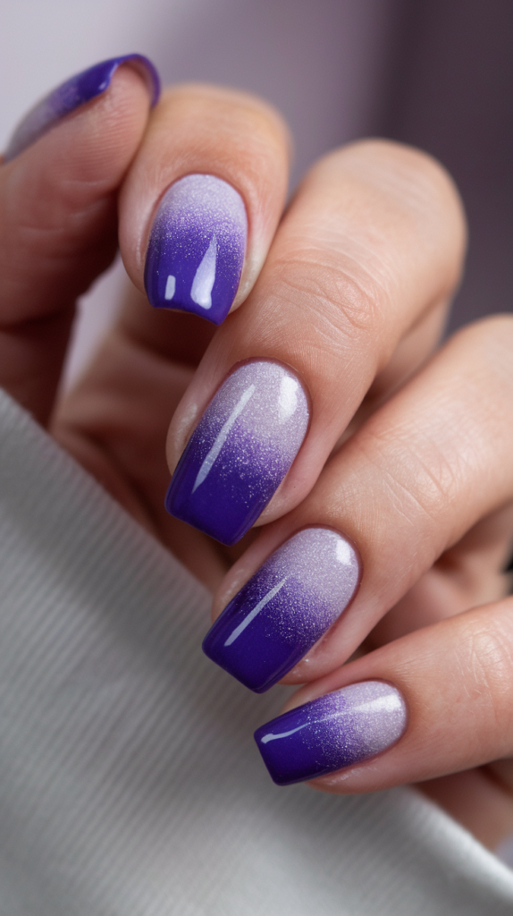 Ombré nails transitioning from light lavender to deep royal purple, embodying regal sophistication.

