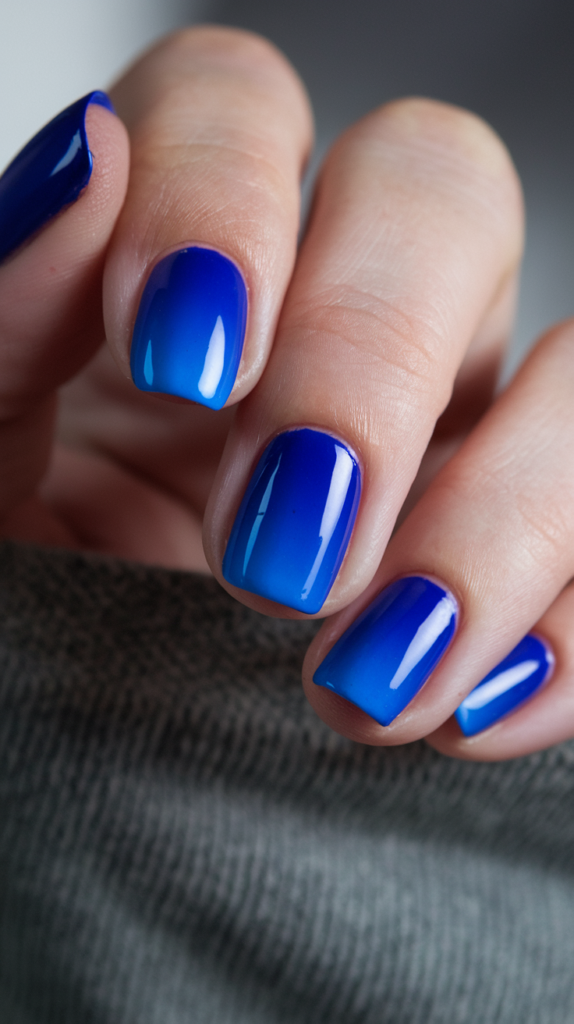 Rich cobalt to vibrant electric blue gradient nails with a glossy shine.